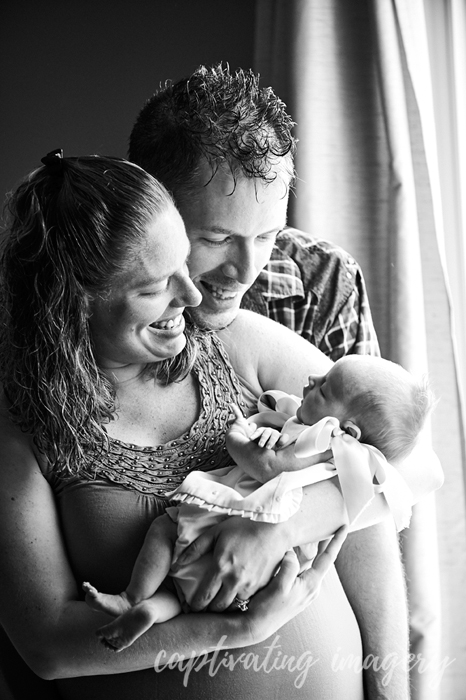 mom, dad, and baby by the window