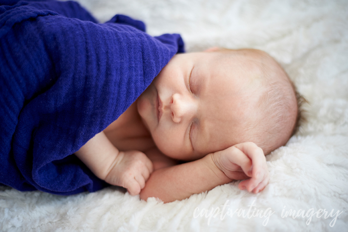 sleepy baby in gauze swaddle