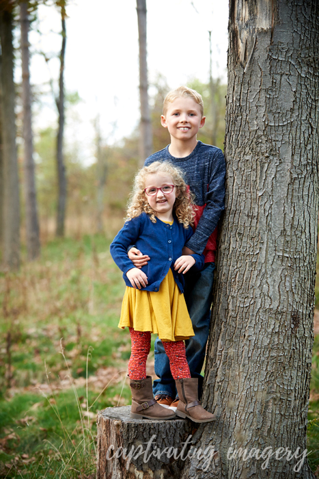 brother and sister on a tree stump