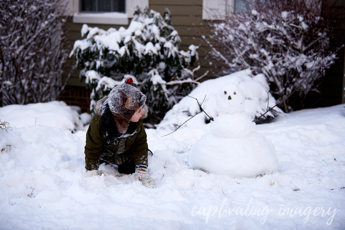 playing with his snowman