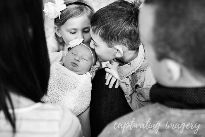 brother and sister checking out baby