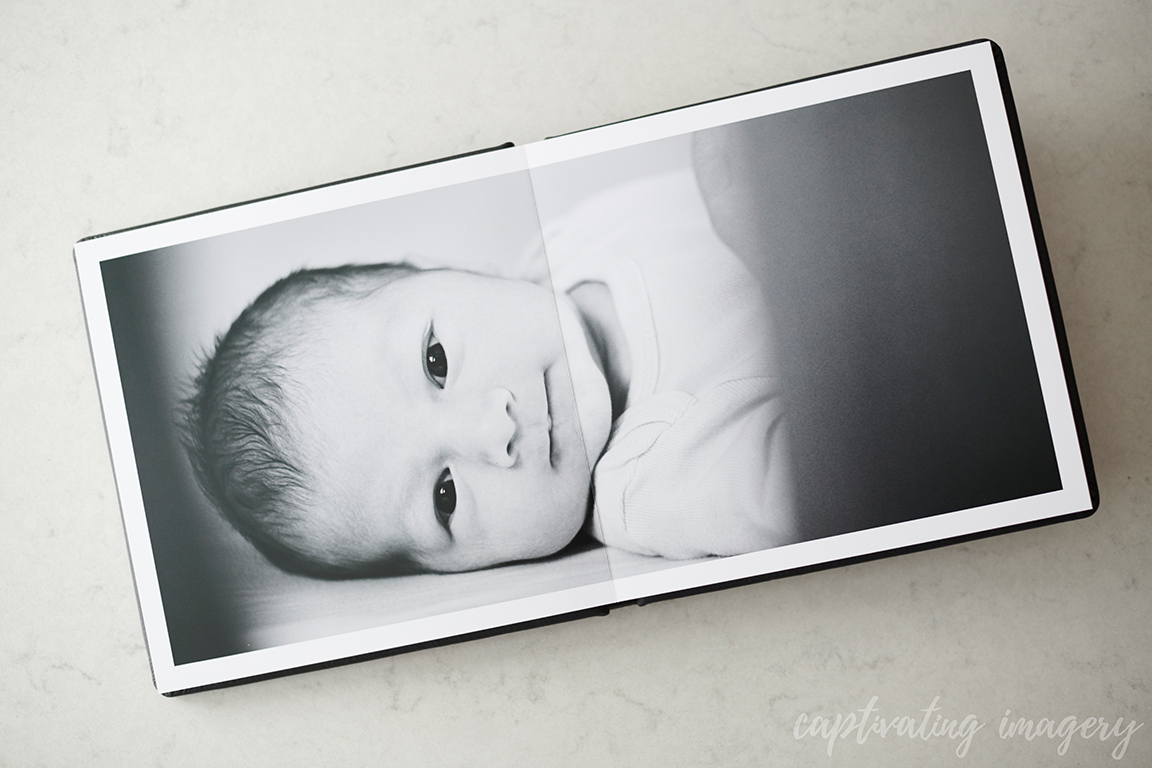 Album open to black and white photo of baby.