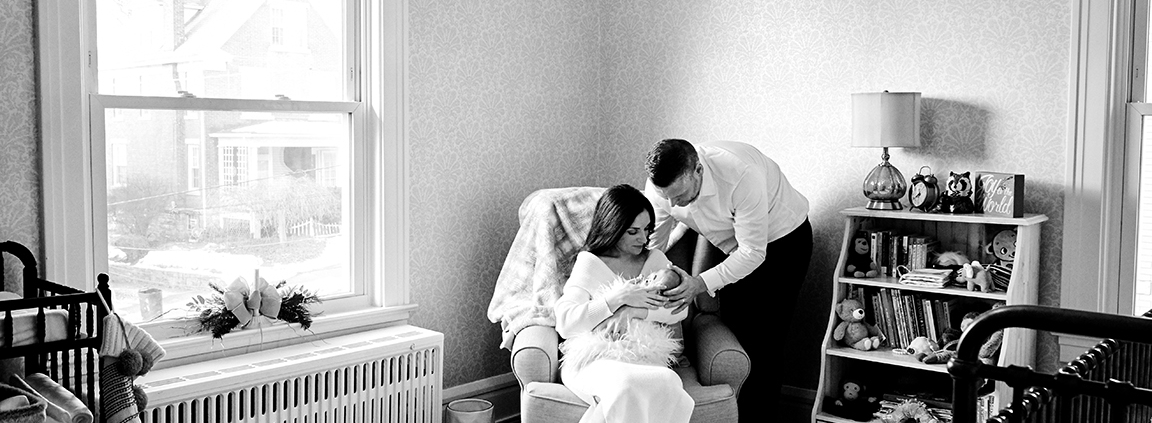 mother, father, and baby together in nursery