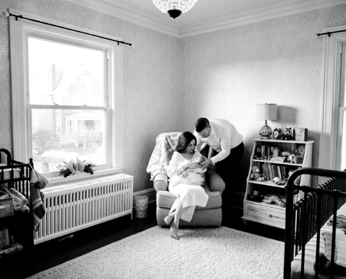 mother, father, and baby together in nursery