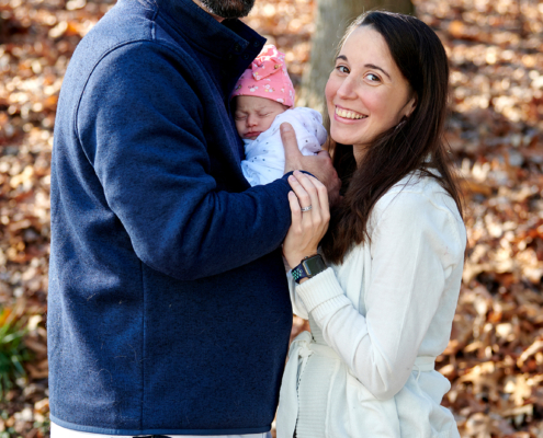 parents hold baby and smile