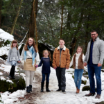 family holding hands on snowy hiking trail
