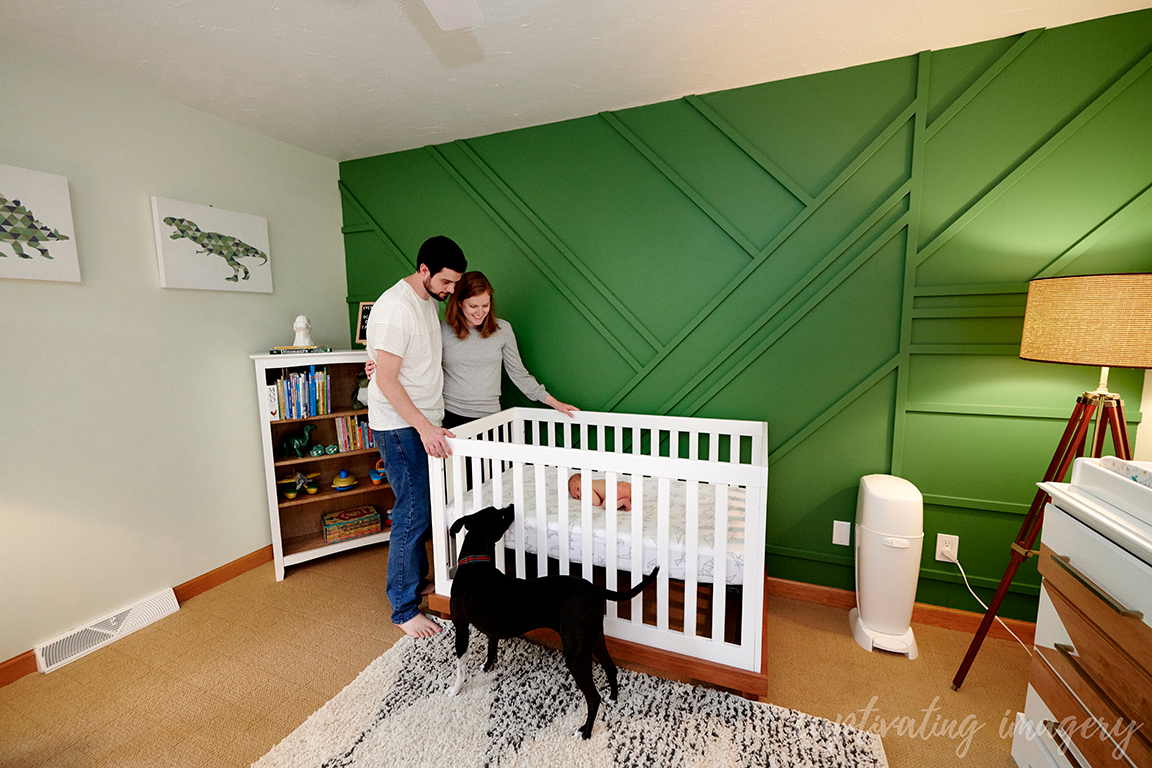 parents look on baby in crib