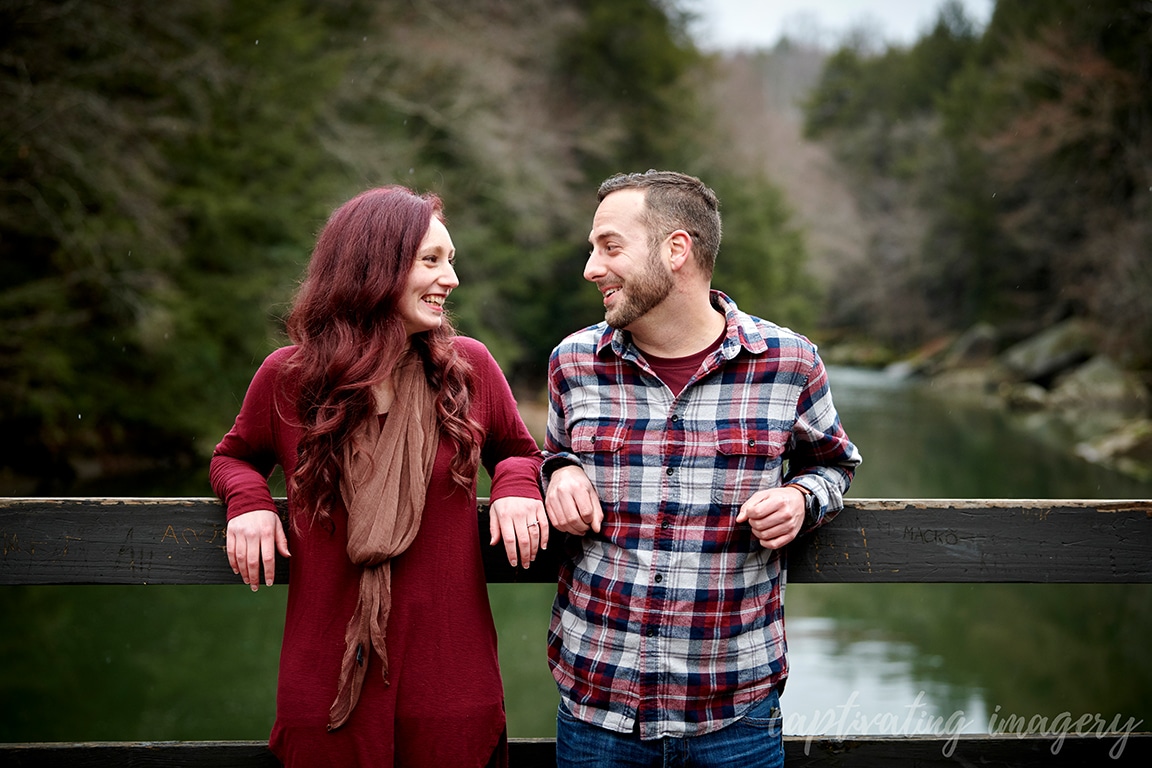 couple laughs together by creek