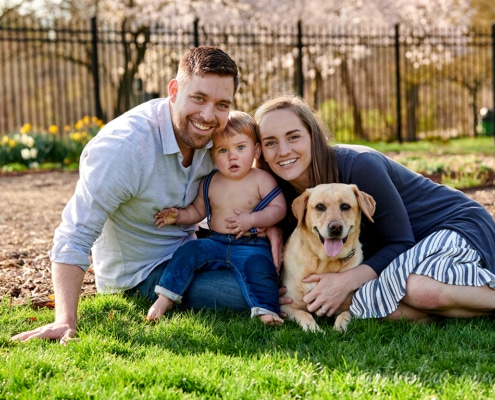 family together on lawn with dog