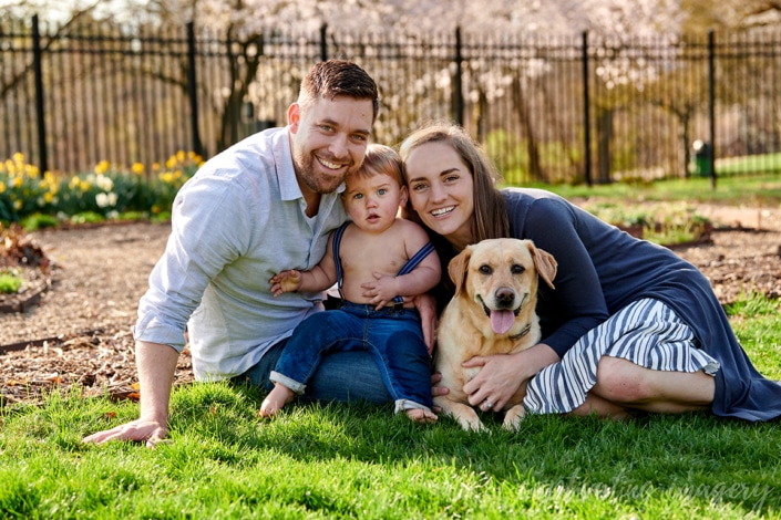 family together on lawn with dog