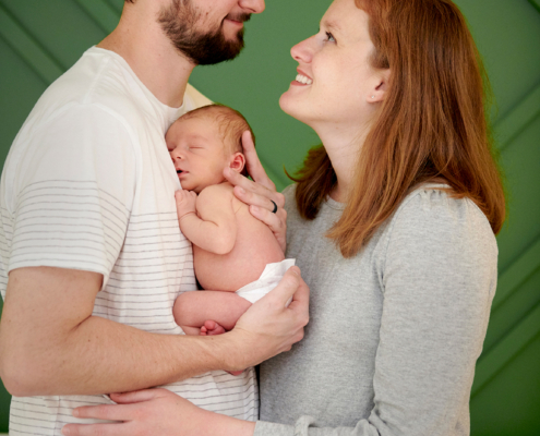 newborn held between parents