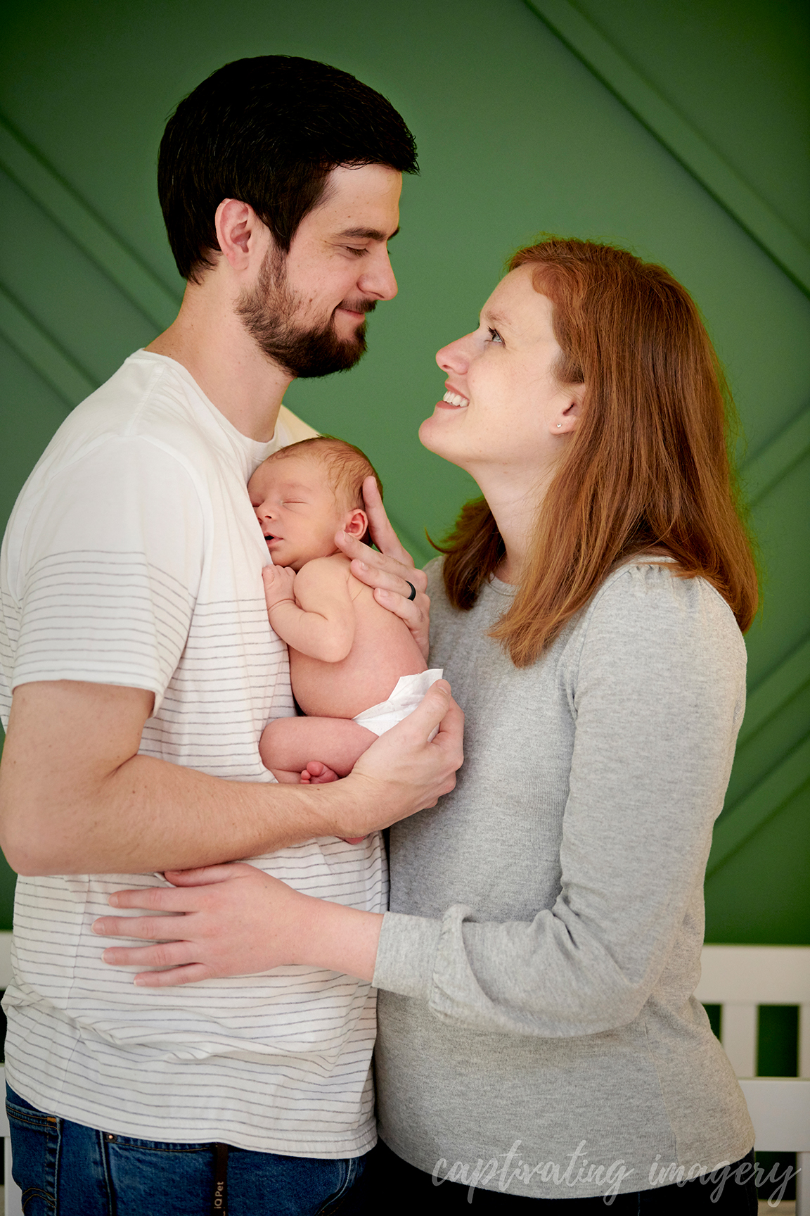 newborn held between parents