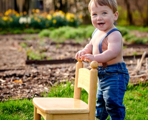 smiling boy with chair and suspenders