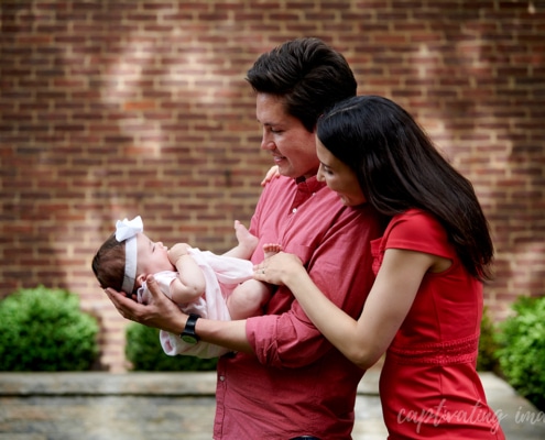 dad holds baby while mom looks on