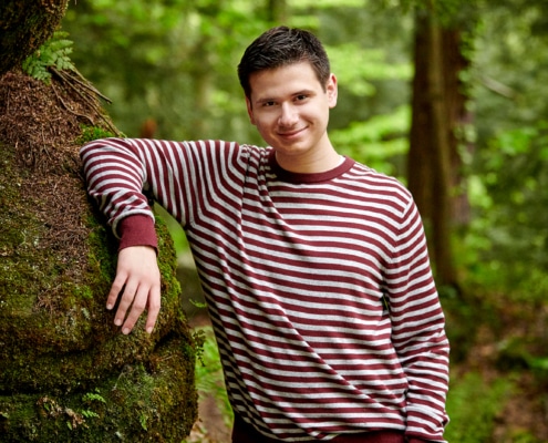 boy leans against rock