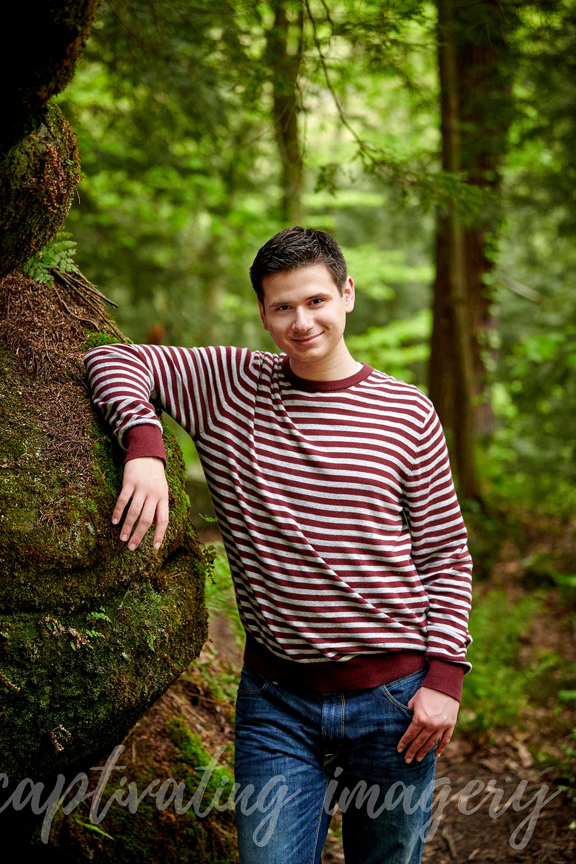 boy leans against rock