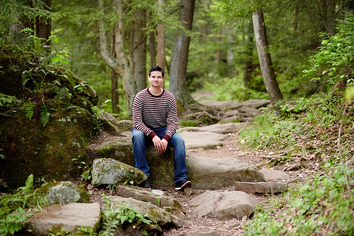boy sits on rock pathway