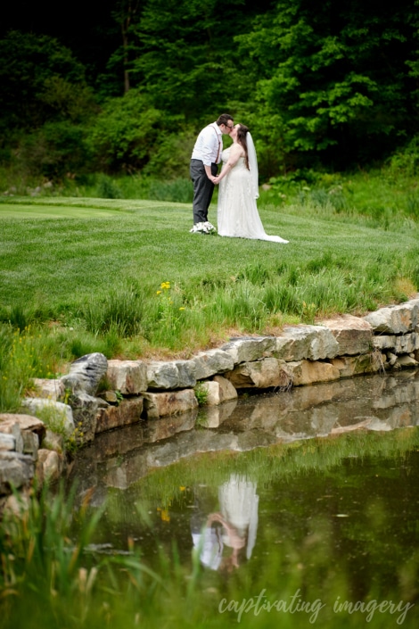 married couple kissing reflected in pond