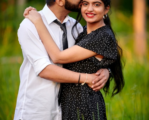 groom-to-be kisses bride-to-be on forehead