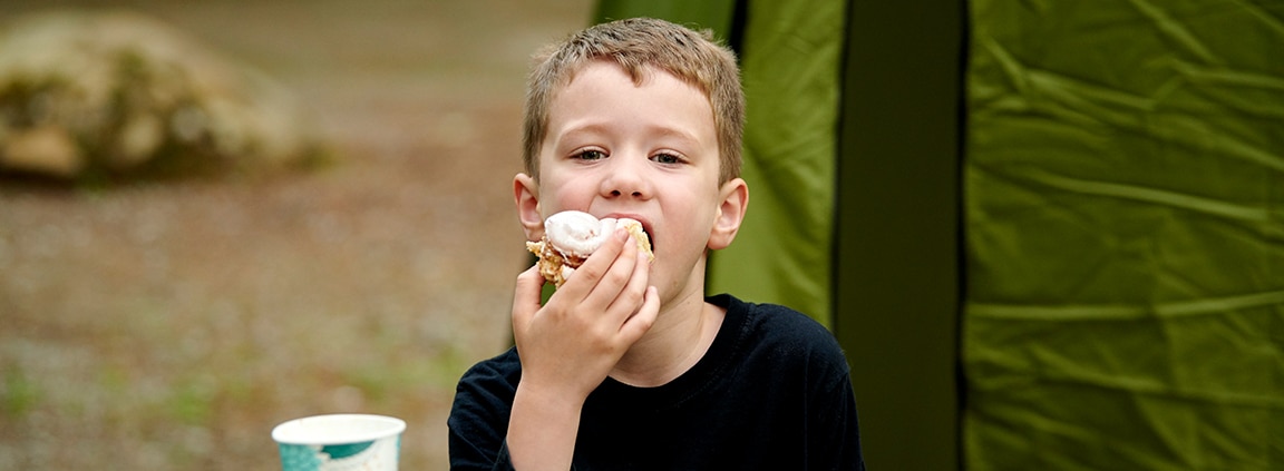 boy eats cinnamon roll