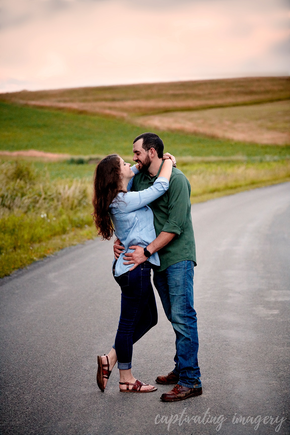 couple embraces in front of sunset