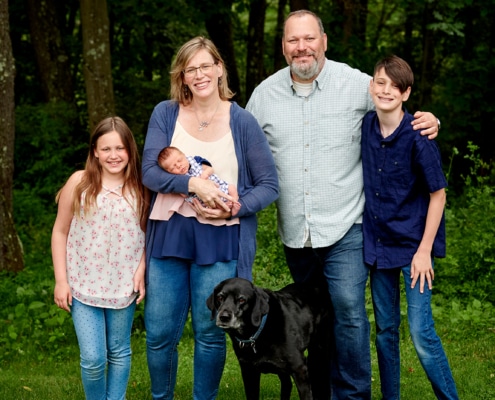 family with newborn in backyard