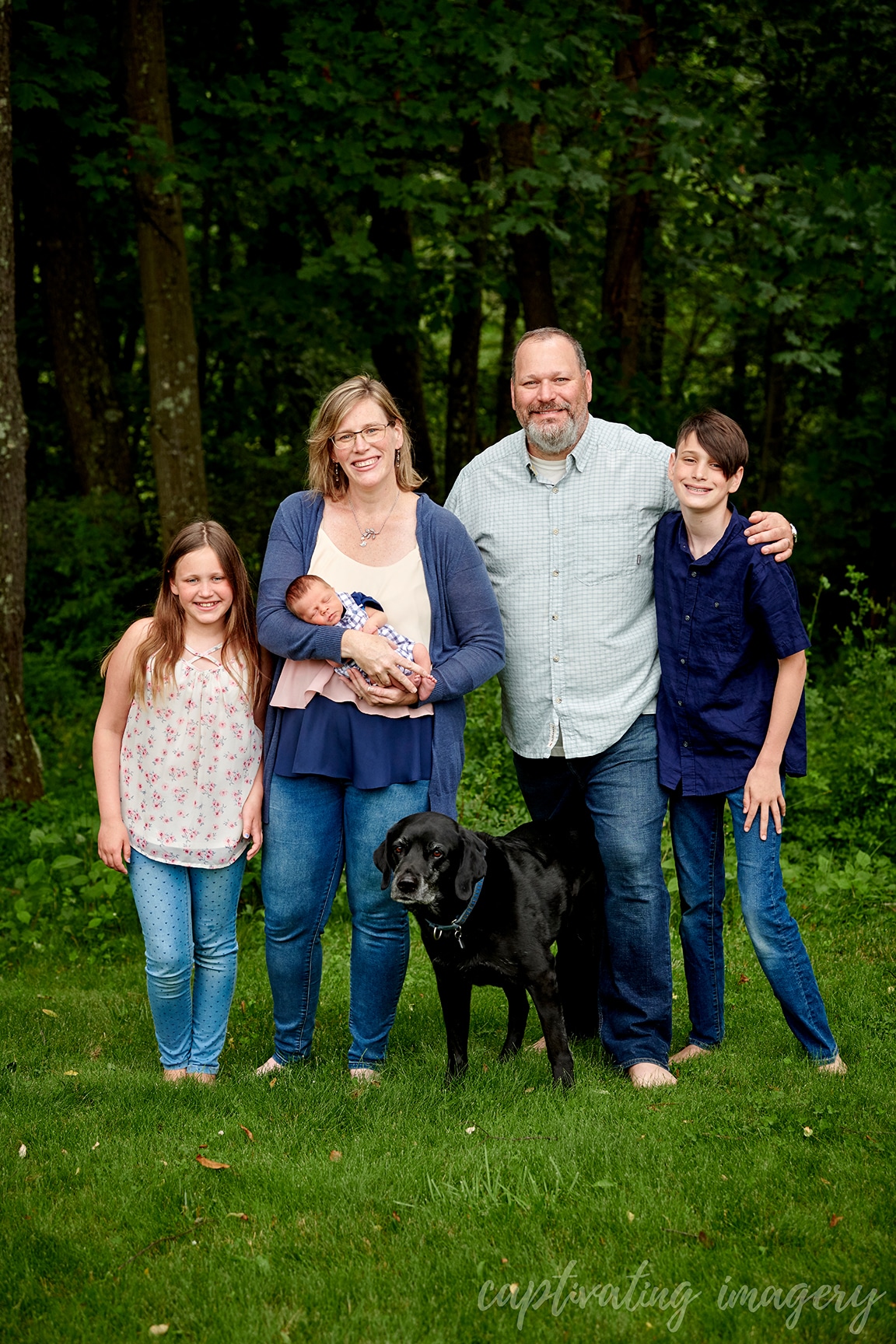 family with newborn in backyard