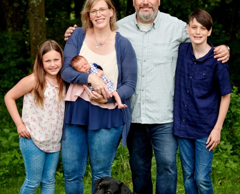 family with newborn in backyard