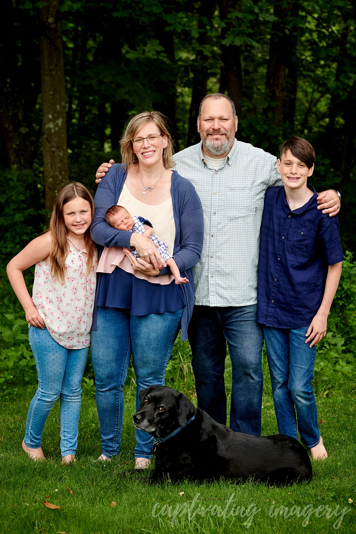 family with newborn in backyard