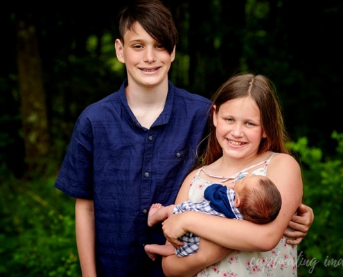 siblings holding baby