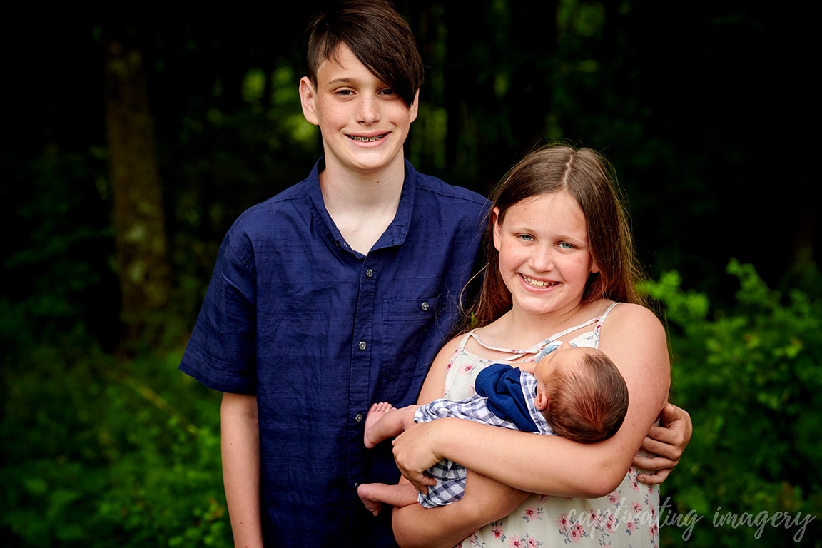 siblings holding baby