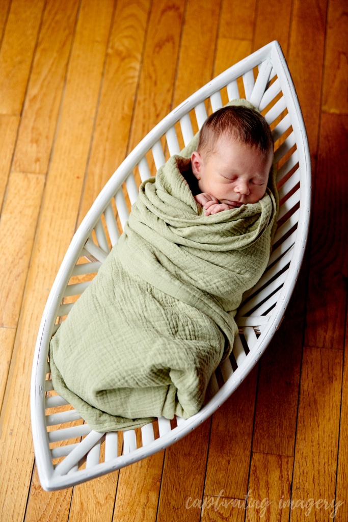 sleeping baby swaddled in basket